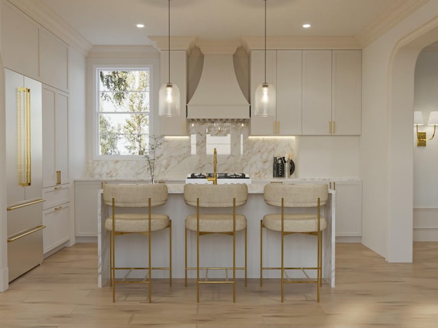 8 Homel Pl, Charleston, SC 29403 - kitchen featuring custom range hood, tasteful backsplash, crown molding, a kitchen island with sink, and arched walkways