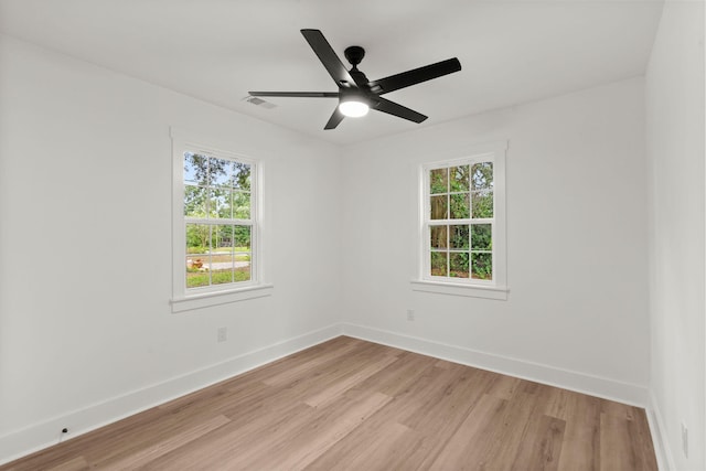 empty room featuring ceiling fan, plenty of natural light, and light wood-type flooring