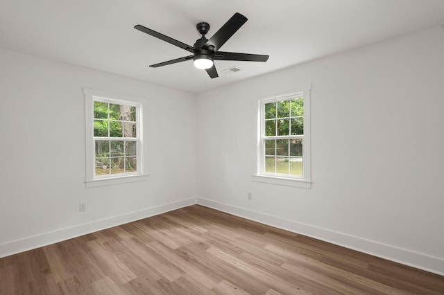 empty room with ceiling fan and light hardwood / wood-style flooring