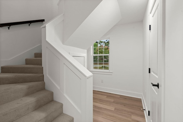 stairs with lofted ceiling and hardwood / wood-style floors