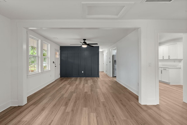 unfurnished living room featuring ceiling fan and light wood-type flooring