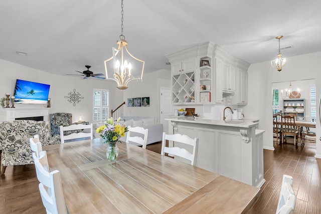 2467 Bergeron Way, Mount Pleasant, SC 29466 - dining room with a chandelier, dark wood-style floors, a ceiling fan, and a fireplace