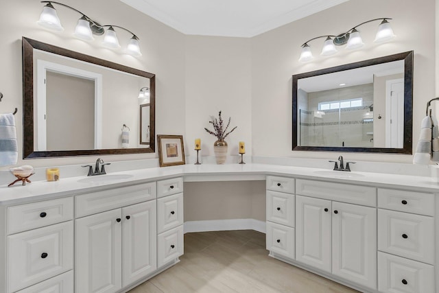 full bath featuring crown molding, a sink, a stall shower, and two vanities