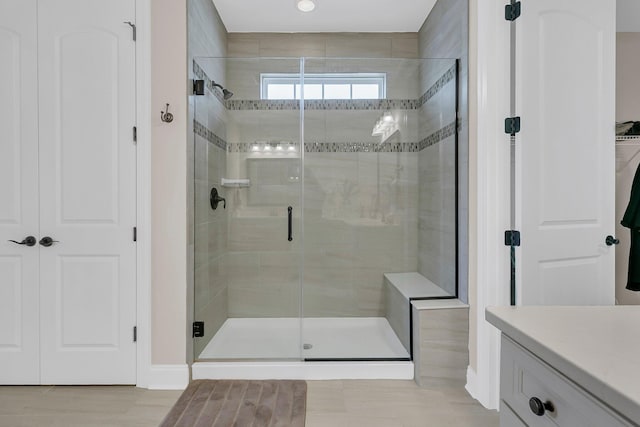 full bathroom with vanity, a closet, and a shower stall
