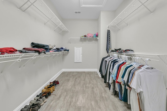 spacious closet featuring visible vents, attic access, and wood finished floors