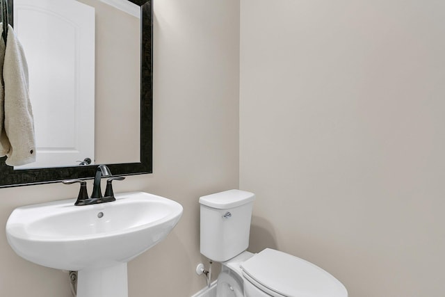 half bathroom with toilet and a sink