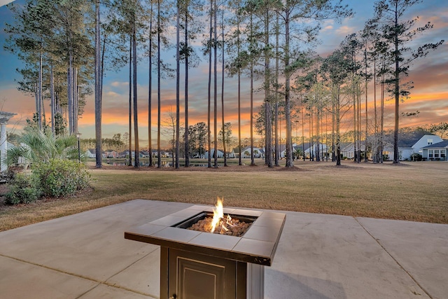 view of property's community with an outdoor fire pit and a yard