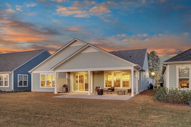 rear view of house with a lawn and a patio area