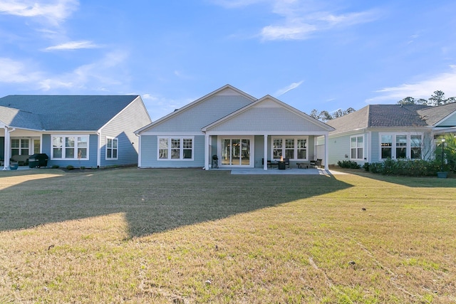 back of house featuring a patio area and a lawn