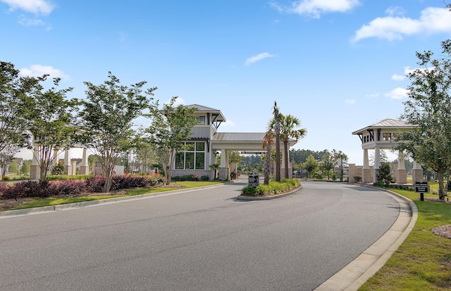 view of road with a gate, a gated entry, and curbs