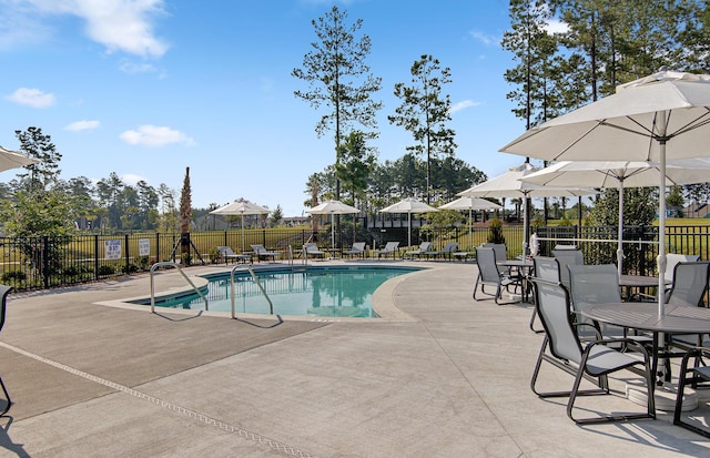 pool with fence and a patio