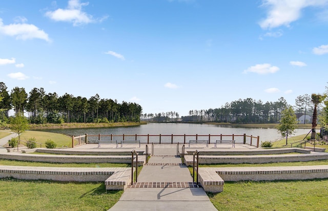 dock area with a water view and a yard