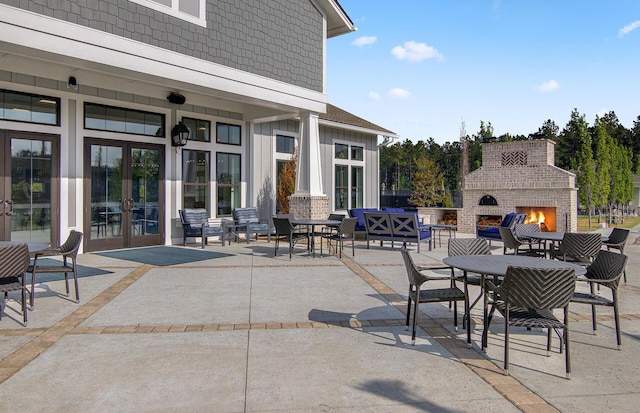 view of patio with an outdoor brick fireplace and french doors