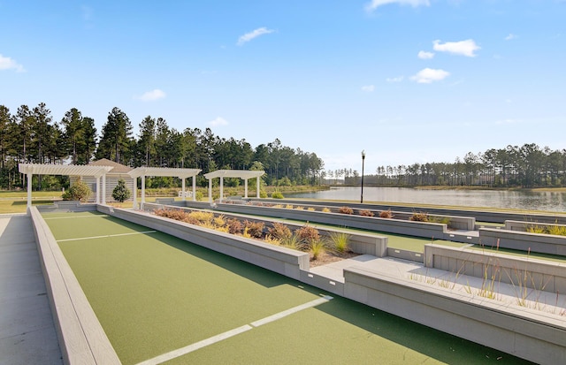 view of community featuring a water view and a pergola