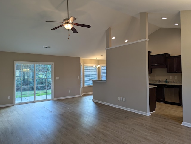 unfurnished living room featuring high vaulted ceiling, ceiling fan with notable chandelier, and hardwood / wood-style flooring