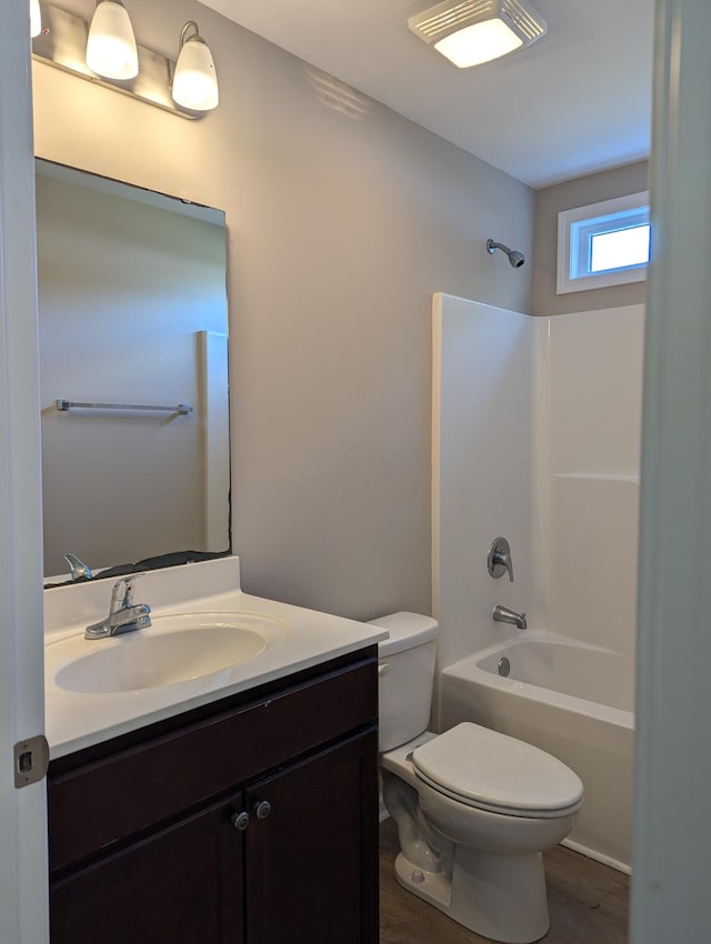 full bathroom with hardwood / wood-style flooring, vanity, toilet, and shower / bathtub combination