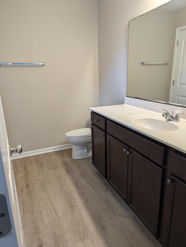 bathroom featuring hardwood / wood-style flooring, vanity, and toilet