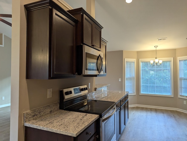 kitchen featuring hanging light fixtures, dark brown cabinetry, light hardwood / wood-style floors, and stainless steel appliances