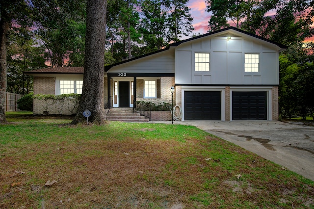 tri-level home featuring a lawn and a garage