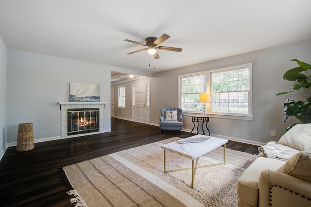 unfurnished living room with a brick fireplace, ceiling fan, and dark wood-type flooring