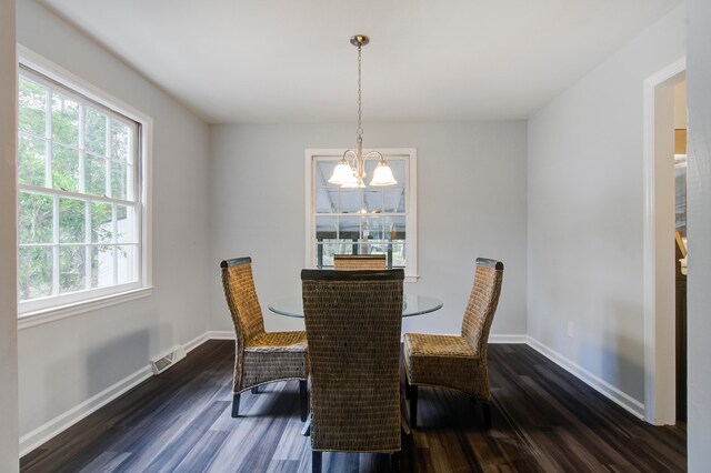 dining area with a notable chandelier and dark wood-type flooring