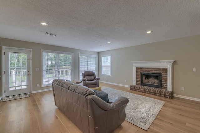 1616 Dotterers Run, Charleston, SC 29414 - living area with a textured ceiling, light wood-type flooring, plenty of natural light, a brick fireplace, and recessed lighting