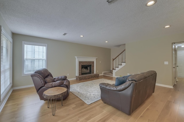 1616 Dotterers Run, Charleston, SC 29414 - living room with a textured ceiling, light wood-type flooring, a brick fireplace, recessed lighting, and stairs