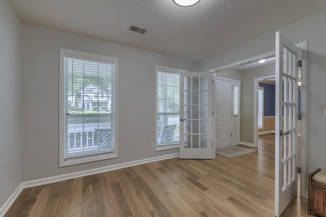 1616 Dotterers Run, Charleston, SC 29414 - empty room featuring french doors, light wood-style floors, and a textured ceiling