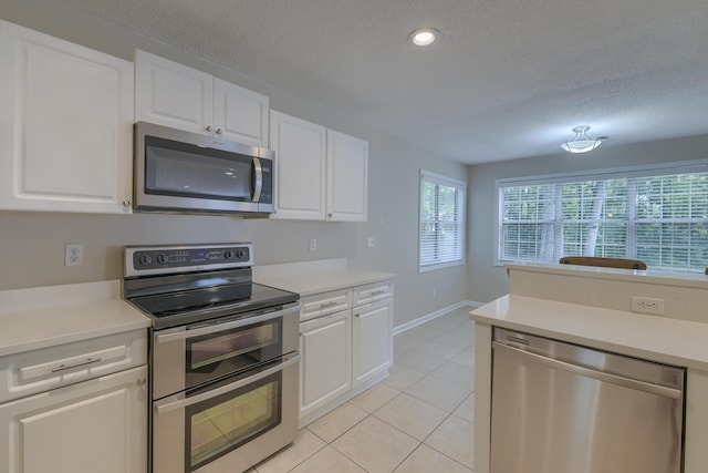 1616 Dotterers Run, Charleston, SC 29414 - kitchen with appliances with stainless steel finishes, light tile patterned flooring, a textured ceiling, light countertops, and white cabinets