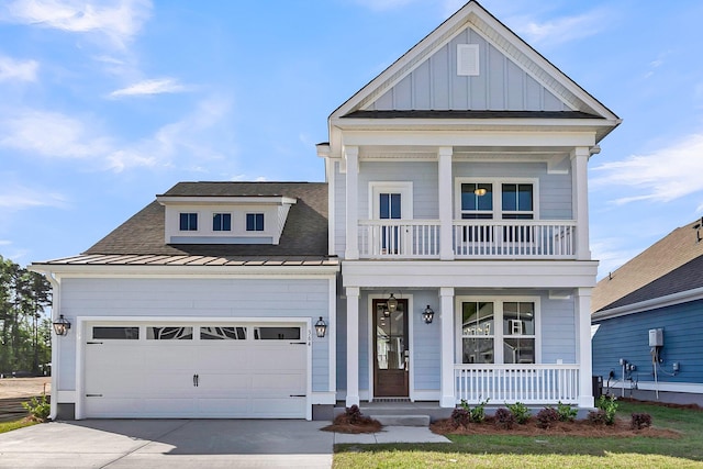greek revival inspired property featuring metal roof, concrete driveway, a balcony, a porch, and a standing seam roof