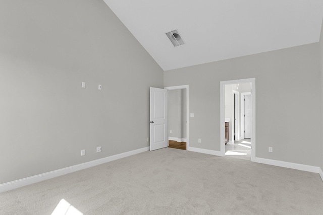 unfurnished bedroom with carpet flooring, ensuite bath, high vaulted ceiling, and baseboards