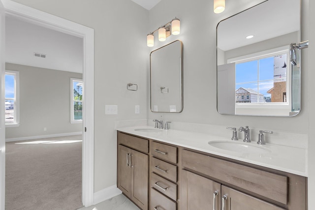 bathroom featuring plenty of natural light, baseboards, and a sink