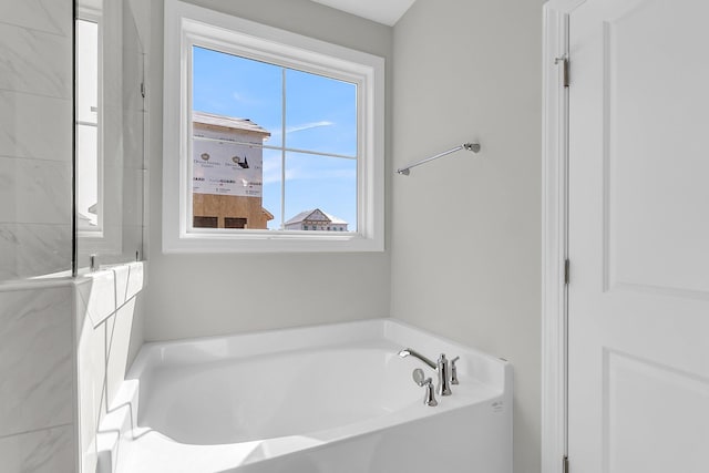 bathroom with a wealth of natural light and a garden tub