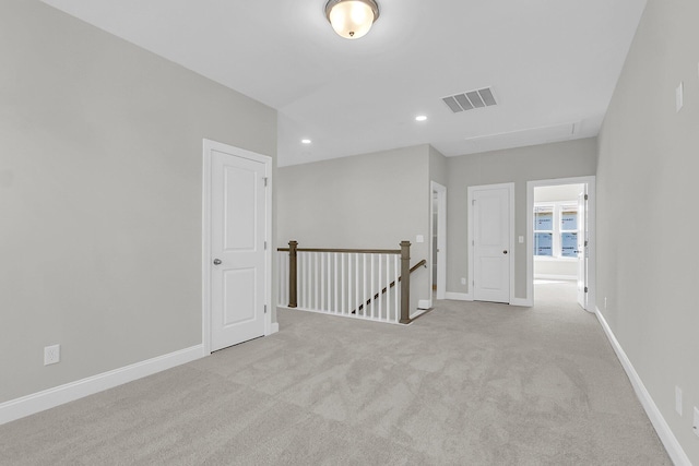 unfurnished room with attic access, visible vents, recessed lighting, carpet floors, and baseboards