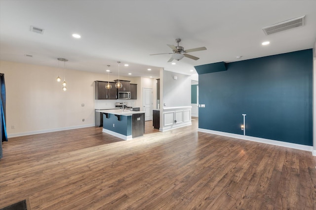 unfurnished living room with ceiling fan and wood-type flooring