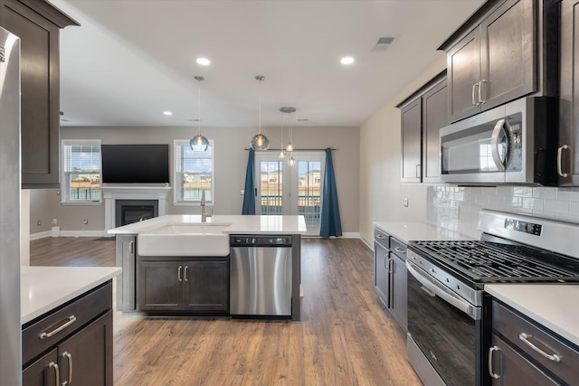 kitchen featuring a wealth of natural light, sink, decorative light fixtures, and appliances with stainless steel finishes