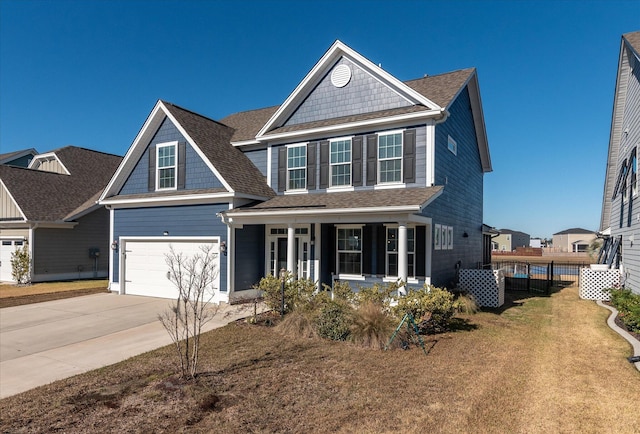 view of front of house with covered porch, a garage, and a front lawn