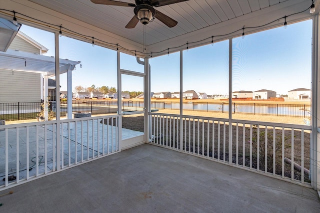 unfurnished sunroom with ceiling fan