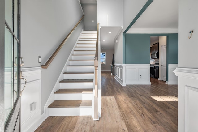 staircase featuring hardwood / wood-style flooring and crown molding