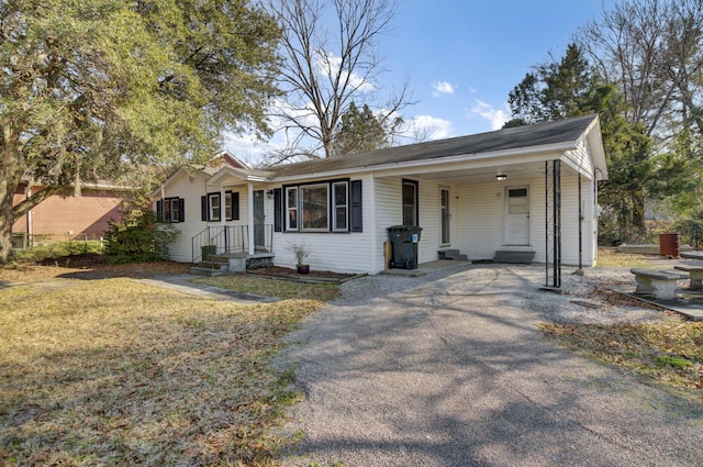 ranch-style house featuring a carport and driveway