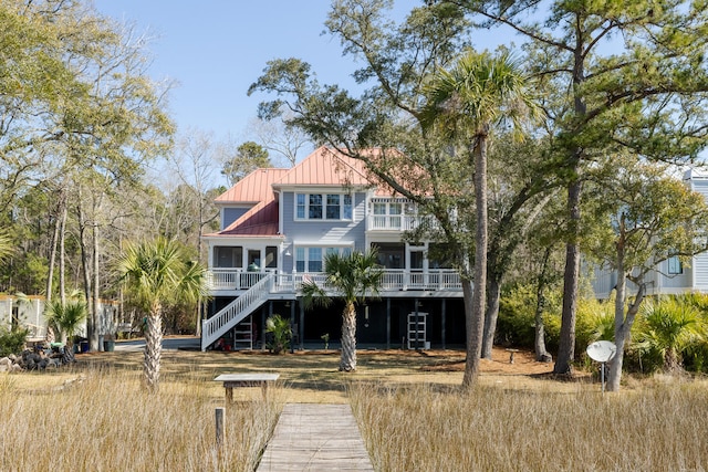 back of property with stairway, metal roof, and a standing seam roof