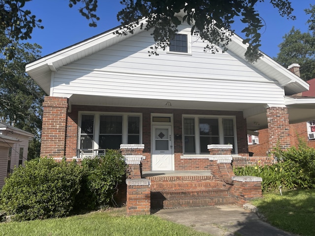 view of front facade with covered porch and brick siding