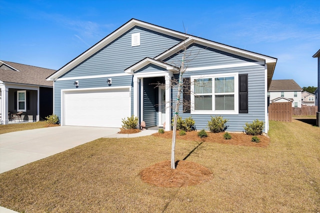 view of front of home with concrete driveway, an attached garage, fence, and a front yard