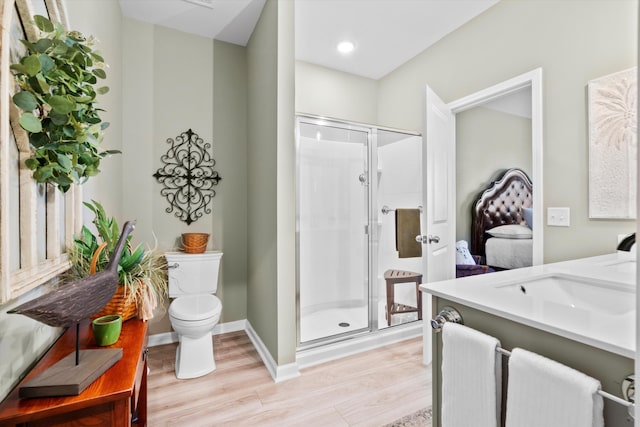 full bath featuring toilet, a stall shower, wood finished floors, and vanity