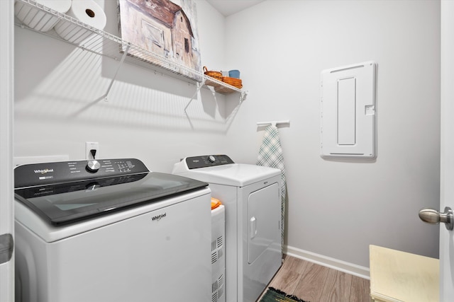 laundry room featuring laundry area, light wood finished floors, electric panel, baseboards, and independent washer and dryer