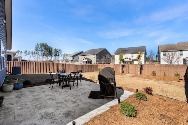 view of patio with a residential view, a fenced backyard, outdoor dining space, and central air condition unit