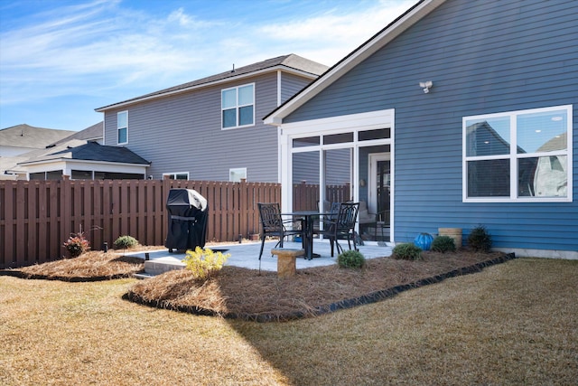 back of property with a yard, a patio area, and fence