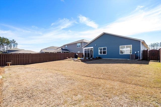 back of house with a patio area, a fenced backyard, a lawn, and central AC