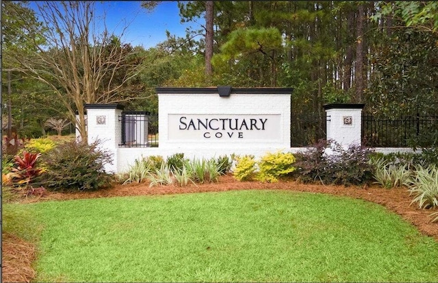 community sign featuring fence and a lawn