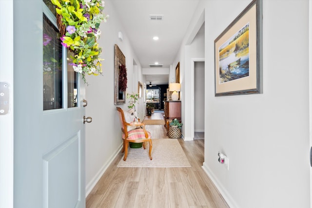 hall with light wood-style floors, visible vents, baseboards, and recessed lighting